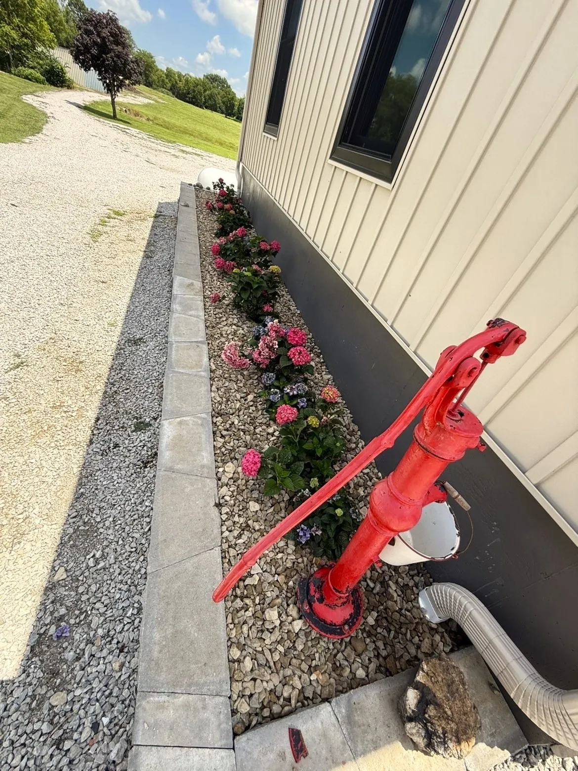 Side yard flower bed with hydrangeas and stone block edging