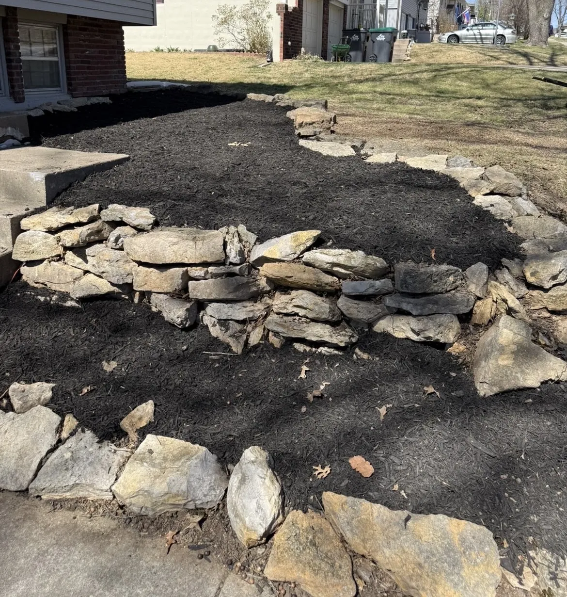 Natural stone retaining wall and mulch bed installation